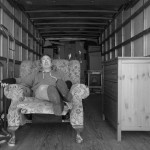Tired man sitting in a chair in a moving truck