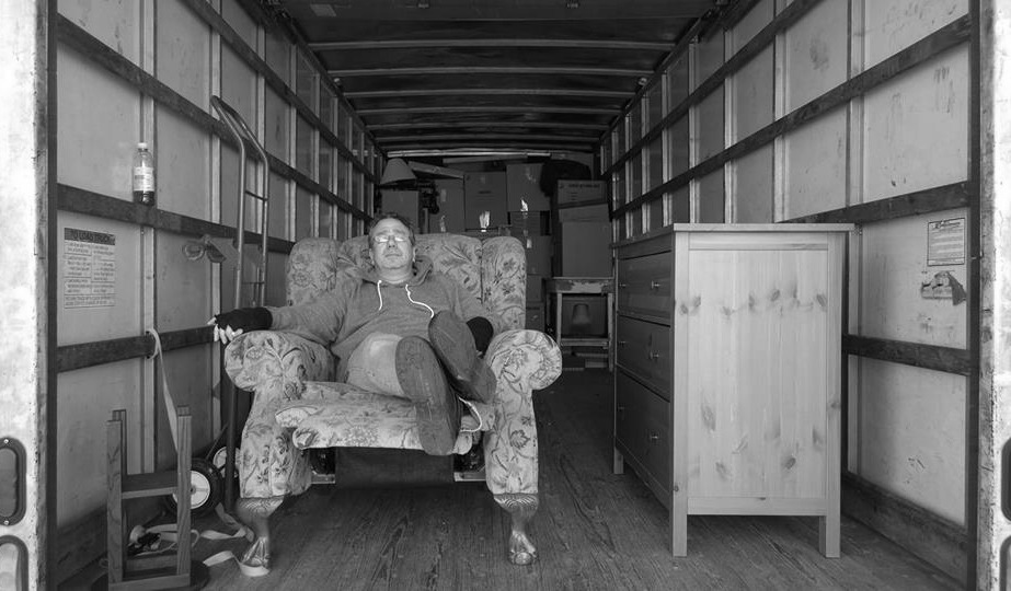 Tired man sitting in a chair in a moving truck