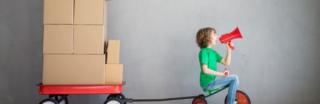 Boy pulling boxes on tricycle