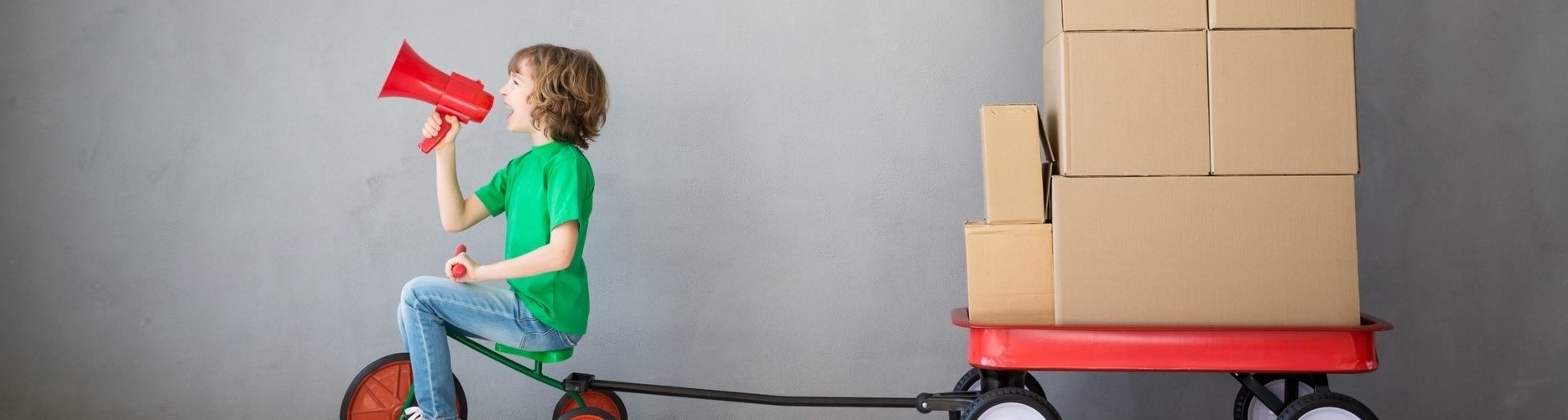 Boy in green shirt pulling boxes on a wagon