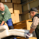 two movers lifting furniture inside mover truck