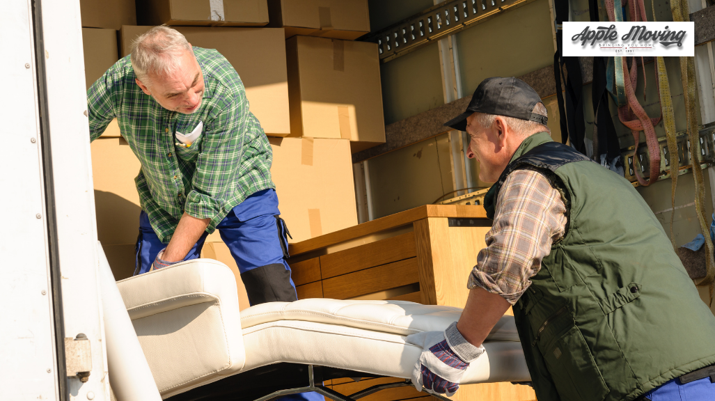 two movers lifting furniture inside mover truck